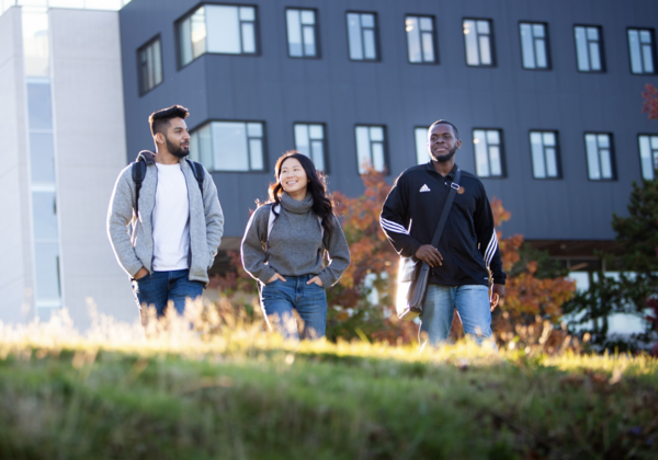 Three students walking and chatting together.