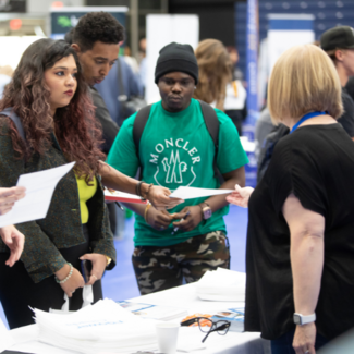 students interacting with employer at career fair